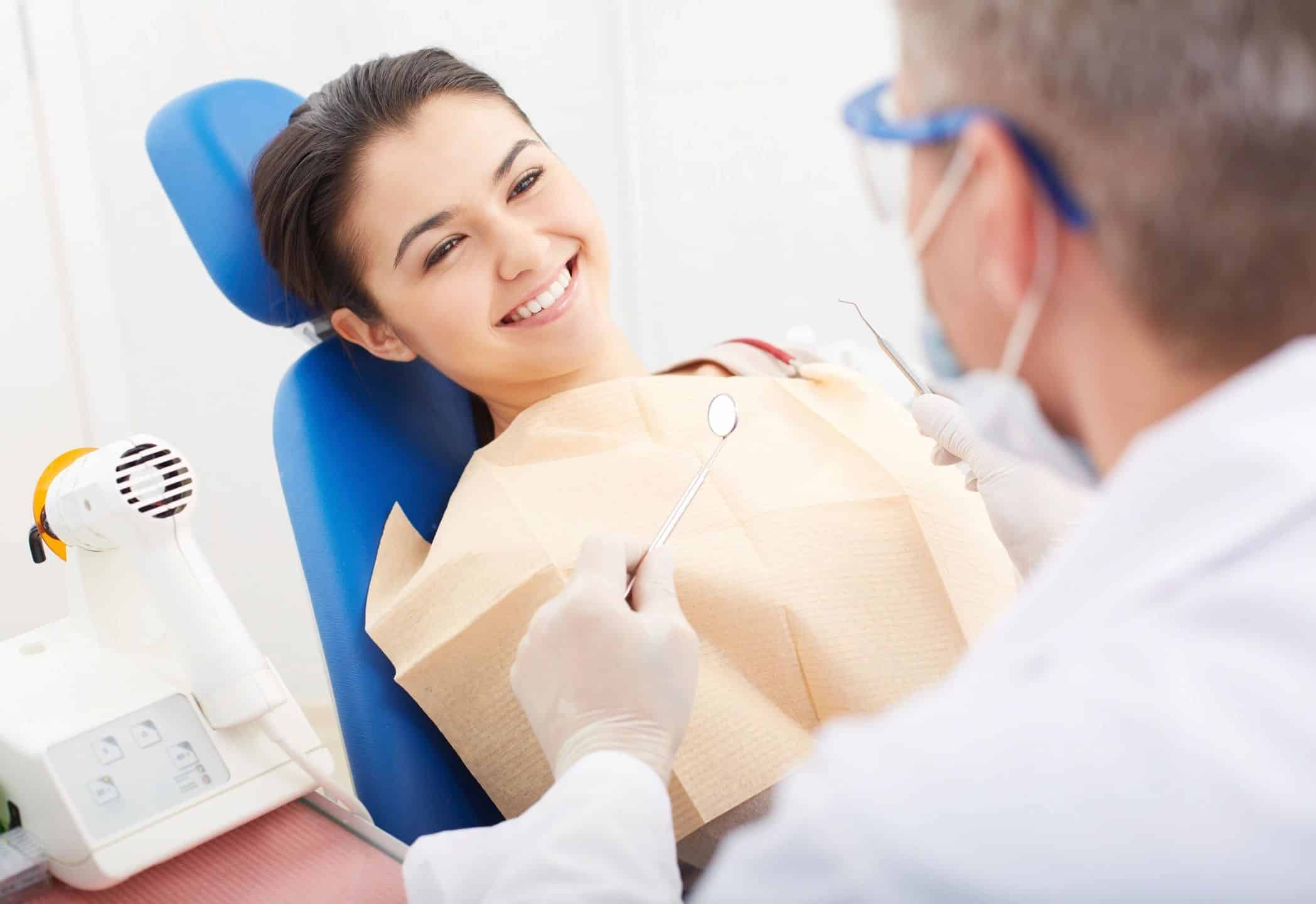 Woman smiling with a dentist ready to examine her teeth