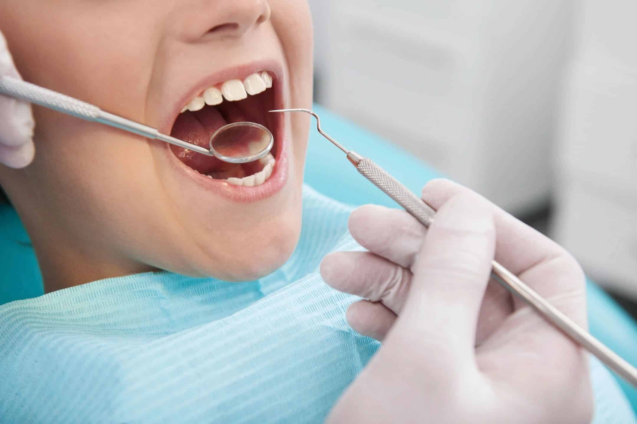 Dentist taking a look in someone's mouth with a mirror
