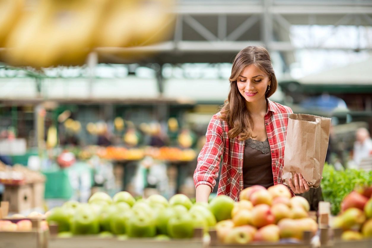 woman in a grocery store picking food good for teeth