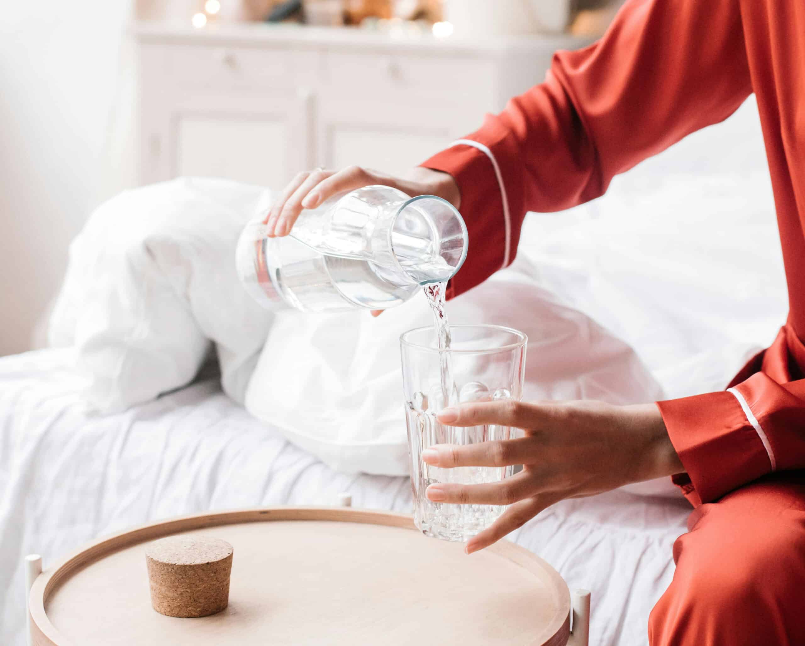 A lady pouring water into a glass