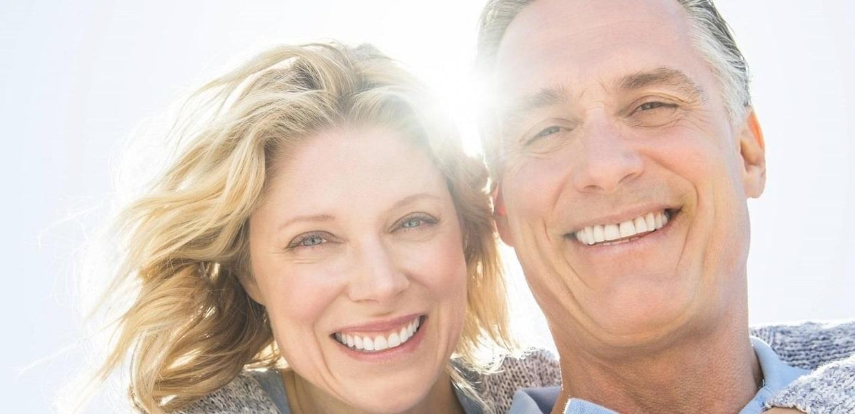 A happy couple smiling with bright white teeth